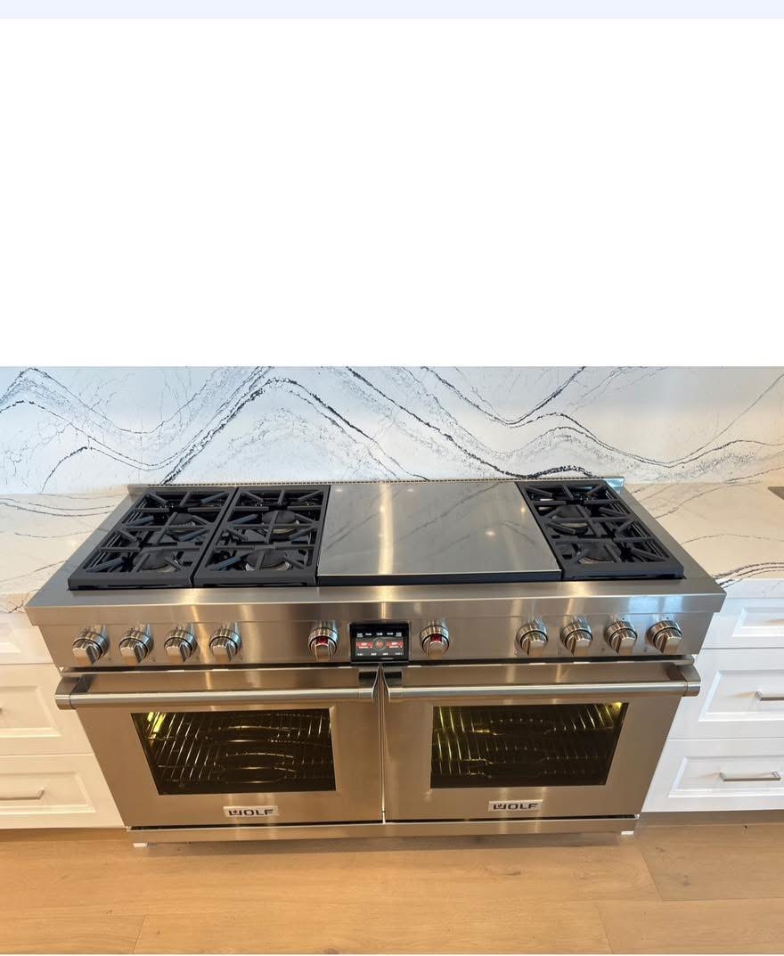Installed Wolf range fitted between white cabinets