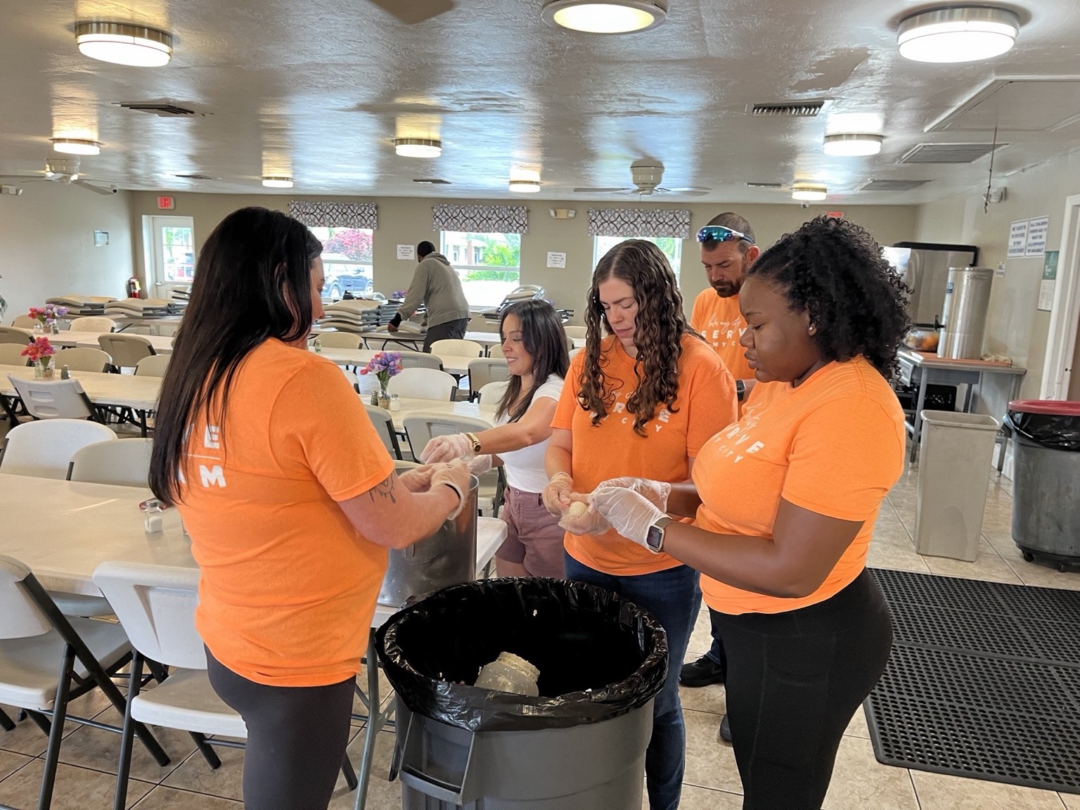 Volunteers preparing food together during a church service project